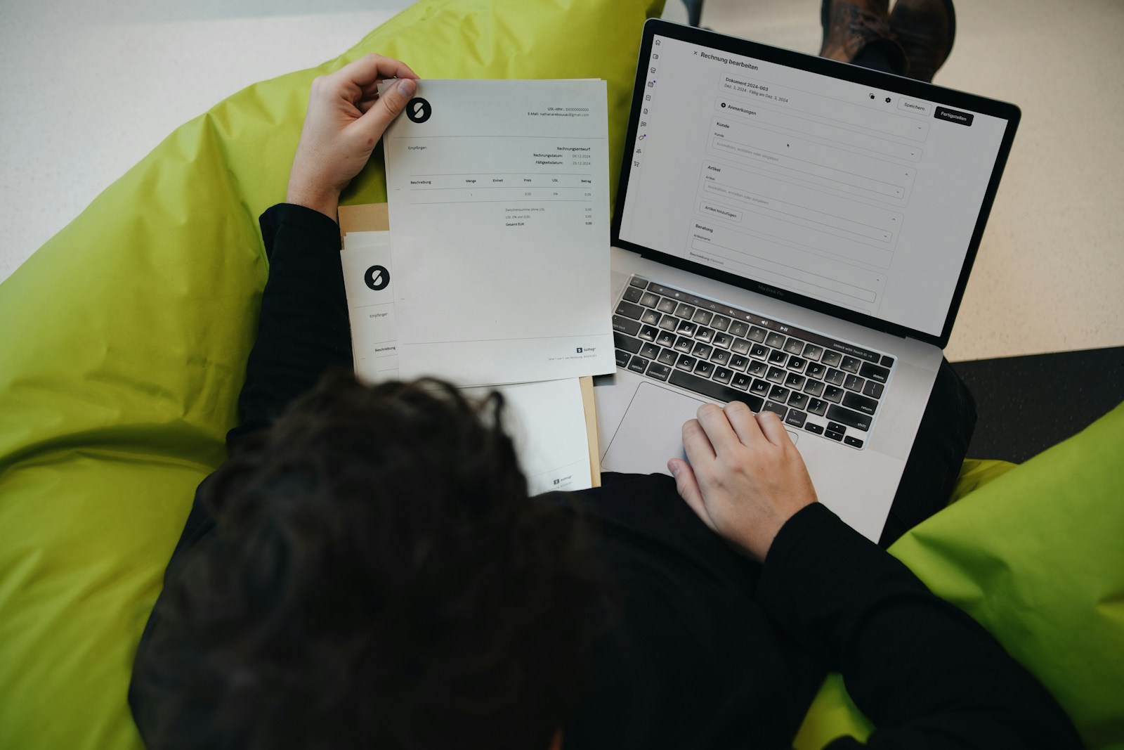 A person sitting on a bean bag chair working on a laptop