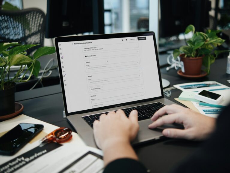 A person typing on a laptop on a desk