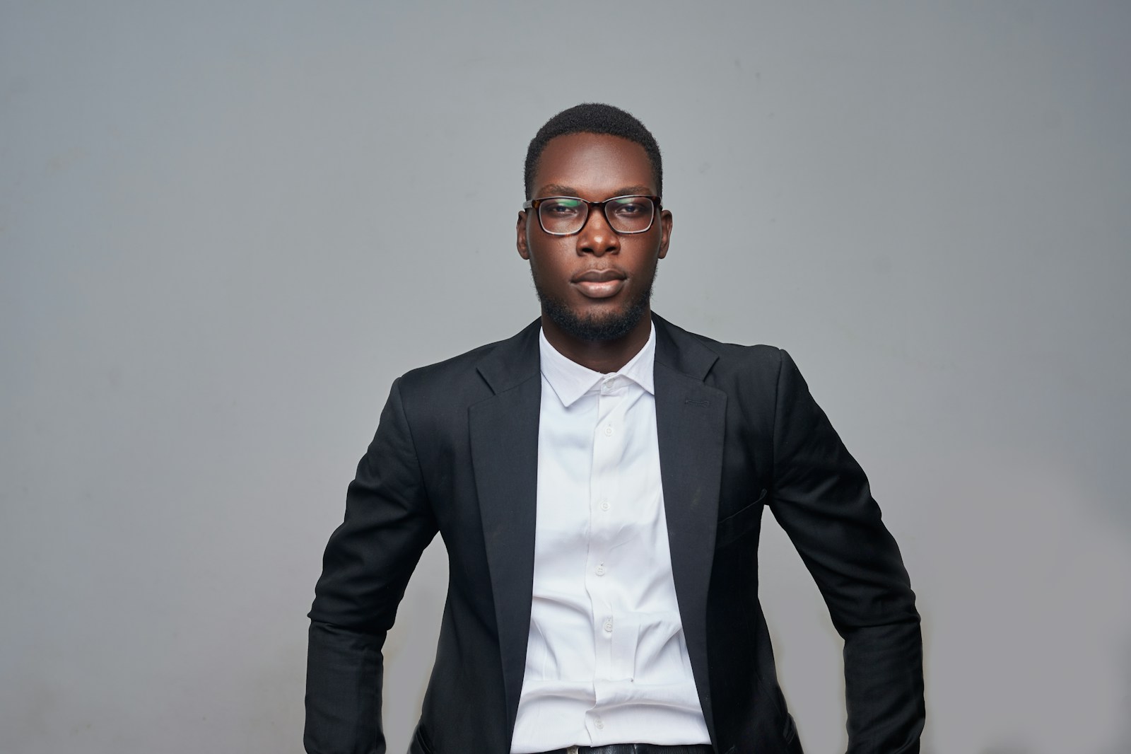 a man in a suit and glasses posing for a picture